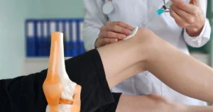 Doctor administering SoftWave Acoustic Therapy injection on knee in Santee, CA